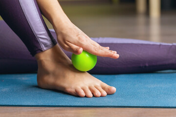 Myofascial relaxation of the hypermobile muscles of the foot and ankle with a massage roller, close-up