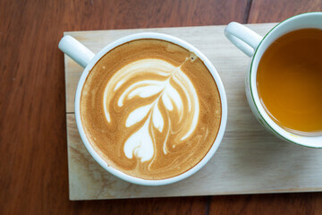 Hot coffee latte a cup of coffee ro cupucino on wood table background with warm morning sunlight concept lifestyle before working , Start day by coffee