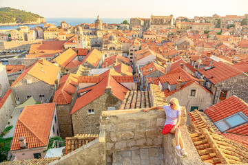 Aerial view of a woman on Dubrovnik walls in Croatia. View of Cathedral of the Assumption of the Virgin Mary and church Crkva sv. Vlaho Saint Biagio of Dubrovnik UNESCO town of Croatia in Dalmatia
