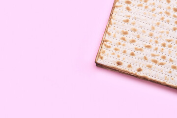 Jewish flatbread matza for Passover on pink background, closeup