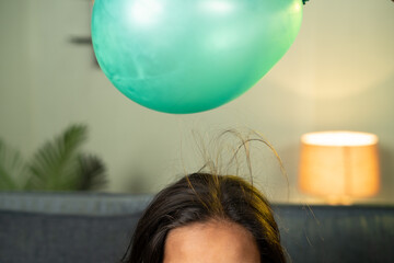 close up shoto of kids playing by placing balloon to attracting hair - conept of static cling home...