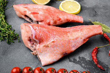 Whole raw red snapper fish, on gray stone table background - obrazy, fototapety, plakaty