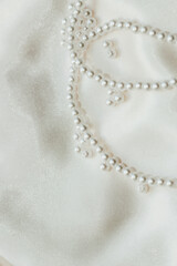 Pearl bijouterie beads on silk texture background.