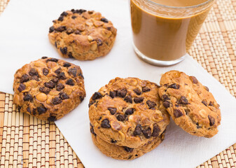 cookies with chocolate and hazelnuts and coffee with milk lie on the table