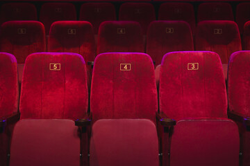 Obraz premium Empty comfortable red seats with numbers in the cinema