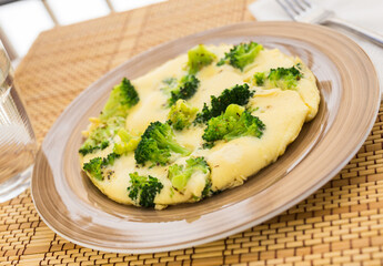 wholesome breakfast. omelet with broccoli on brown plate