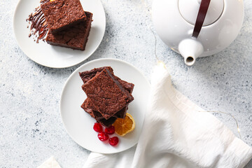 Plates with pieces of delicious chocolate brownie on light background