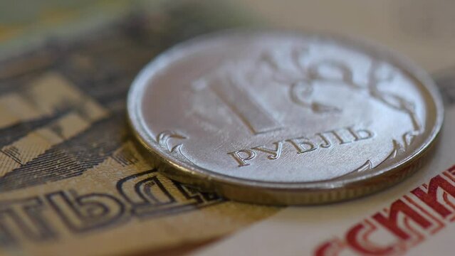 Argent liquide de la F&eacute;d&eacute;ration de Russie : d&eacute;tail de billets de banque et pi&egrave;ce de monnaie de 1 rouble avec les mots "rouble" et "Russie" &eacute;crits en langue russe. Rotation lente