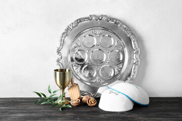 Passover Seder plate with kippah and cup on table against white background