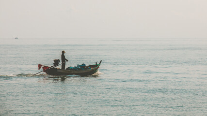 Fishing boat and fisherman at sea or ocean water.
