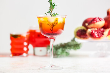 Glass of tasty pomegranate cocktail on light background