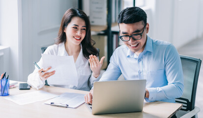Two Asian businesspeople working at office