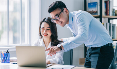 Two Asian businesspeople working at office