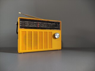 Vintage yellow transistor radio, dark grey background, listen music concept