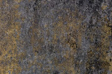 Old faded yellow cement wall surface and black mold. indicative of a period