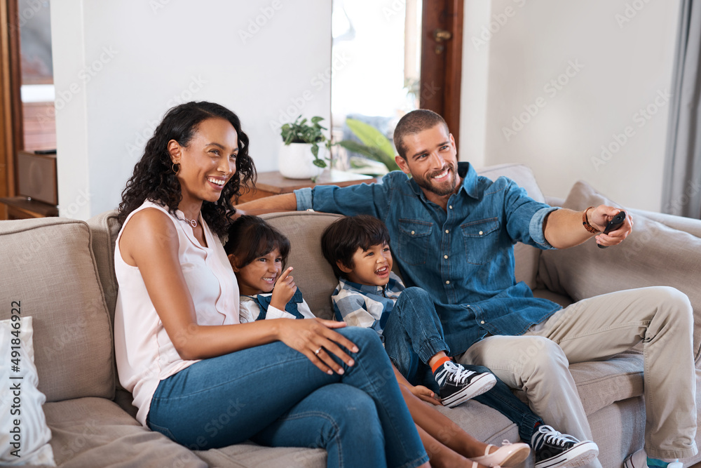 Canvas Prints Its movie time for the whole family. Shot of a couple watching something on the television with their two young kids.