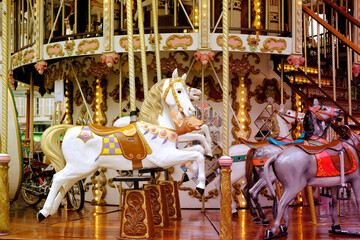 children's carousel is decorated with multicolor lights, decorations, a fairground ride with horses...