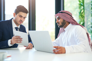 Complimentary skill sets for a successful collaboration. Shot of a young muslim businessman using a...