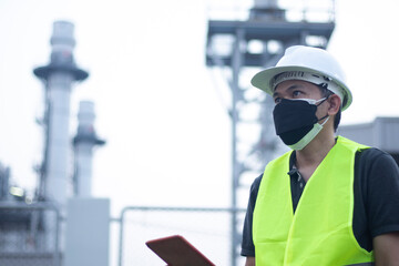 Engineer wearing mask working and laptop at power plant