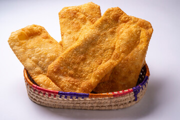 Brazilian pastries in a basket over white background.