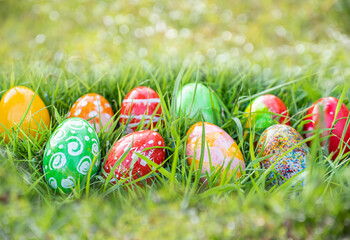closeup, many beautiful painted easter eggs as grass blurred background. concept for good friday, easter monday, spring full moon. copy space on top for text or design. garden, nobody, selective focus