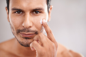 Fototapeta premium Moisturizing like a boss. Cropped shot of a handsome young man taking care of his skin.
