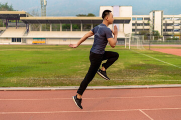 Fototapeta premium Sports and recreation concept a young male adult running in low speed in the sports stadium as his healthy routine in the evening