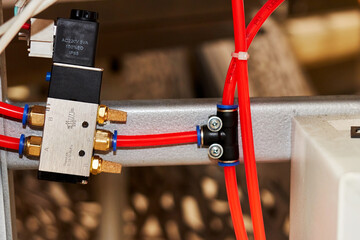 orange duct tubes of pneumatic system connected to solenoid electric valve - obrazy, fototapety, plakaty