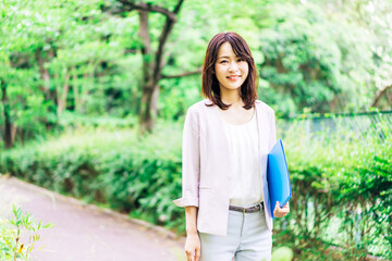 書類を持って歩く若いビジネスウーマン