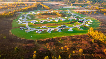 Aerial view of a new RV Park in a Kansas state park with motorhomes, 5th wheels, and travel trailers on concrete pads.