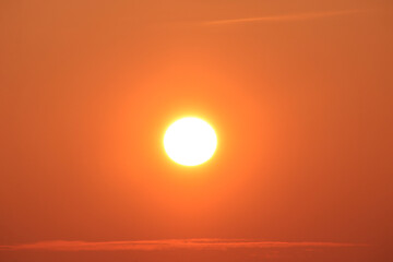 Sun disk at sunset and thin stripes of clouds horizontal photo