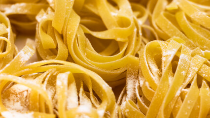 Nest pasta from durum wheat sprinkled with flour on a white background. Close-up. Spikelets of wheat. Home cooking. Pasta background.