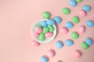 chocolate Easter eggs in a white plate on a pink background 