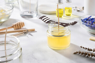 Set tools for homemade natural eco-friendly soy wax candles, wick, perfume, essential oil on a marble table. Making process. Trendy DIY. Craft hobby, small business, artisan products concept