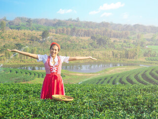 Beautiful lady wearing red traditional dress of eastern Europe smiling happily with tea leaves in...