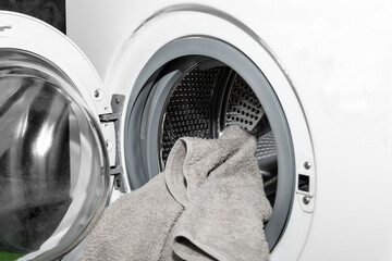 Unloading out the laundry from the washing machine. Loading clothes in a washing machine