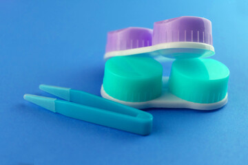 Colored cases for contact lenses for eyes on a blue background.
