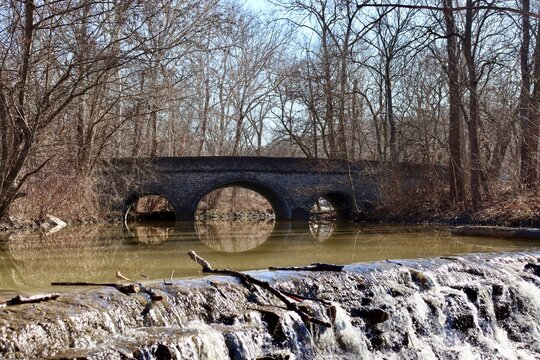 The old stone bridge in the park on a sunny day.