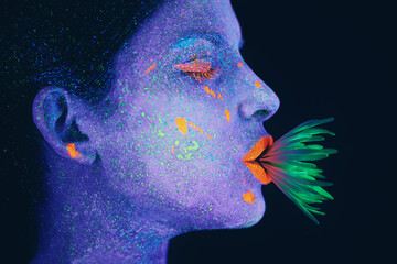 Life in neon. Shot of a young woman posing with neon paint on her face.