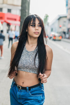 beautiful latina girl with brown skin walking down the street in the city of Pereira-Colombia. young university student on her way to college very optimistic and happy for her achievements.