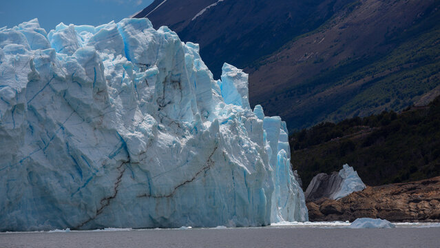 Beeindruckend, die mächtige Eisfront des Perito Moreno Gletschers im Nationalpark Los Glaciares in Patagonien mit spitzen Eiszacken und tiefen Brüchen, welche im Sonnenlicht blau schimmern