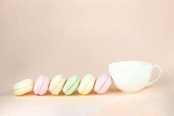 Gourmet Colored marshmallows looks like Macaroon Cookies with porcelain white coffee cup mug, concept of sweet dessert, traditional delicious.