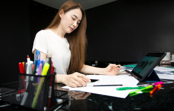 asian woman designer imagination on achitecture blueprint paper on table