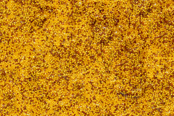 Abstract Dijon mustard background with dark and light mustard seeds