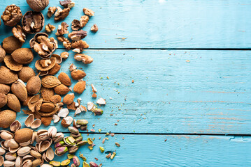 A pile of dried fruits, organic, pistachios, almonds, walnuts, freshly harvested, on a wood, in a market.