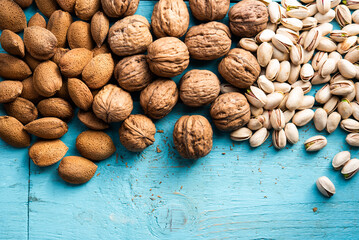 A pile of dried fruits, organic, pistachios, almonds, walnuts, freshly harvested, on a wood, in a market.