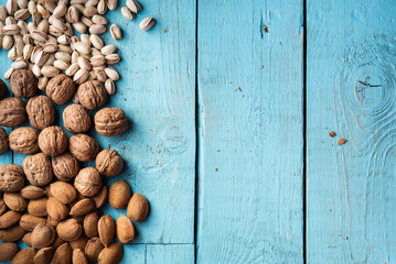 A pile of dried fruits, organic, pistachios, almonds, walnuts, freshly harvested, on a wood, in a market.