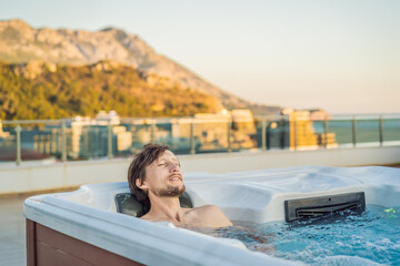 Portrait of young carefree happy smiling man relaxing at hot tub during enjoying happy traveling...