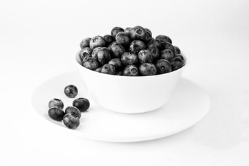 Blueberry in white bowl and plate on white background.