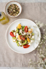 Healthy egg and avocado salad. Salad for breakfast with tomato, avocado, feta, pine nuts, sesame, flax seeds and boiled egg on a concrete background
